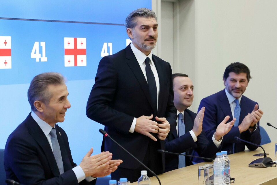 Tidligere fotballspiller Mikheil Kavelasjvili er valgt til Georgias nye president av landets nasjonalforsamling. Han er kritisk til vestlige liberale verdier. Mikheil Kavelasjvili (oppreist) får applaus av blant annet Bidzina Ivanisjvili (t.v.), den styrtrike oligarken som leder Georgisk drøm. Bildet ble tatt på et møte i slutten av oktober der partiet diskuterte hvem som skulle bli partiets presidentkandidat. Foto: Georgisk drøm via AP / NTB