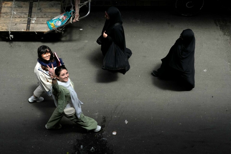 To kvinner uten tildekket hår møter to kvinner som er dekket til fra hode til tå i Teheran. Irans regjering har vedtatt å utsette innføringen av en kontroversiell skjerping av landets kleskoder for kvinner. To kvinner uten tildekket hår møter to kvinner som er dekket til fra hode til tå i Teheran. Irans regjering har vedtatt å utsette innføringen av en kontroversiell skjerping av landets kleskoder for kvinner. Foto: Vahid Salemi / AP / NTB