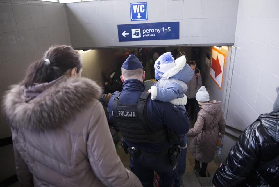 På togstasjonen i Przemysl hjelper alle til. Her bærer en polsk politimann en liten gutt fra Odesa til perrongen. Den lille gutten skal videre til Warszawa sammen med sin søster og mor. Togstasjonen i Przemysl.