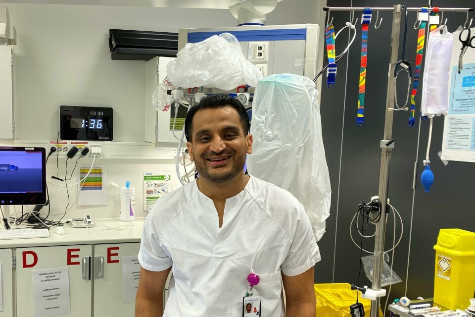 Overlege Adeel Anwar er spesialist i indremedisin. Nå er han også spesialist i akutt- og mottaksmedisin, og skal hjelpe pasienter på akuttmottaket med å få riktig og rask behandling. Adeel Anwar i hvit legeskjorte i et rom på sykehuset