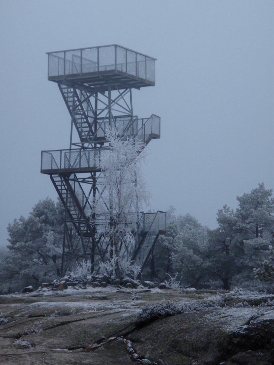 I tåke er utsikten til tårnet bedre enn utsikten fra toppen, men på gode dager ser du langt og lengre enn langt. Utkikkstårn i snø og tåke.