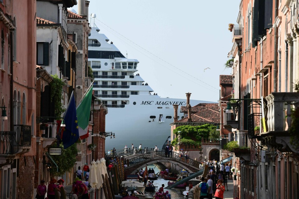 Et cruiseskip lurer i bakgrunnen i Venezia. Lokale innbyggere har i flere år ønsket å forby cruiseskip fra å legge til kai i Venezia, men de er fremdeles tillatt. Et cruiseskip lurer i bakgrunnen i Venezia. Lokale innbyggere har i flere år ønsket å forby cruiseskip fra å legge til kai i Venezia, men de er fremdeles tillatt.