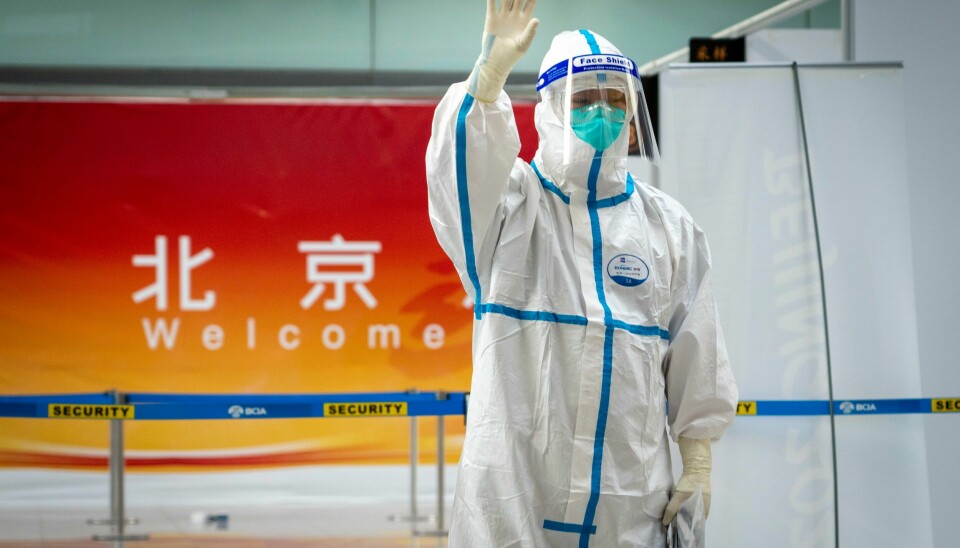 Velkommen! En flyplass-ansatt i fullt smittevernutstyr ønsker norske og svenske OL-utøvere, støtteapparat, trenere og presse velkommen til Beijing. Velkommen! En flyplass-ansatt i fullt smittevernutstyr ønsker norske og svenske OL-utøvere, støtteapparat, trenere og presse velkommen til Beijing.