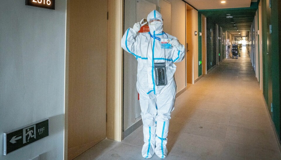 En stuepike, ikledd fullt smittevernutstyr hilser på et hotell i OL byen Zhangjiakou. En stuepike, ikledd fullt smittevern utstyr hilser på et hotell i OL byen Zhangjiakou.