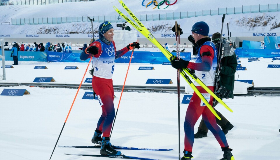 Vetle Sjåstad Christiansen tas i mot av Johannes Thingnes Bø i målområdet fredag. Vetle Sjåstad Christiansen (til v.) og Johannes Thingnes Bø sikret to norske medaljer på fellesstarten. Foto: Torstein Bøe / NTB