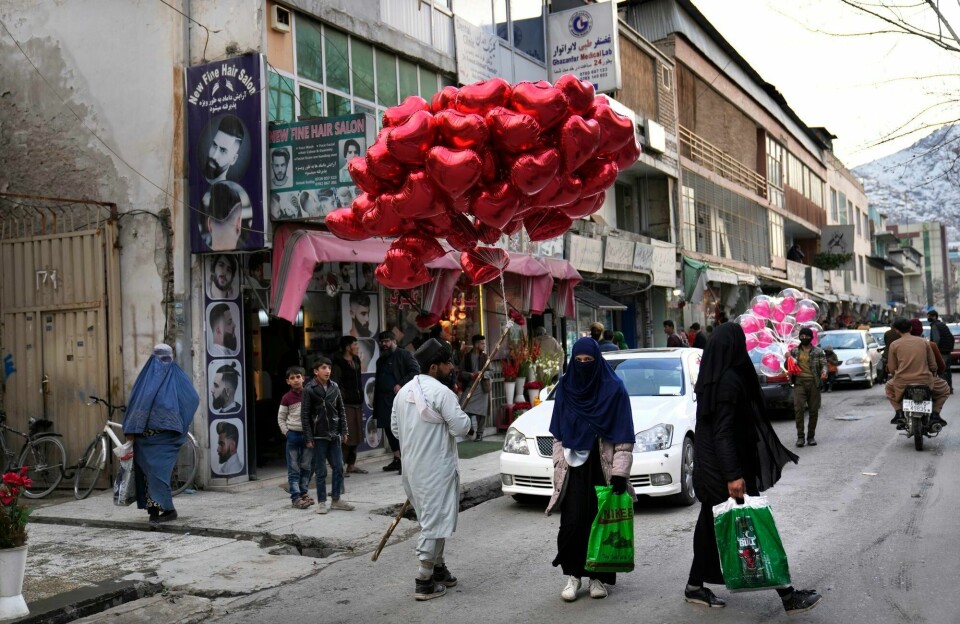 En del av frykten har lagt seg i Afghanistan seks måneder etter at Taliban tok makten i landet. Blant annet har kvinner vendt tilbake til gatene. Dette bildet er fra Kabul på Valentine's Day hvor selgere prøver å få omsetning av sine røde og rosa ballonger. Afghan women pass next of a street vendor who sells red heart-shaped balloons during the Valentine's Day, in Kabul, Afghanistan, Monday, Feb. 14, 2022. Six months since Kabul was ceded to the Taliban with the sudden and secret departure of U.S.-backed president residents say a calm has settled on the country, but the future is uncertain as the economy teeters on the verge of an economic collapse and the new Taliban rulers tackle the transition from war to relative peace. (AP Photo/Hussein Malla)