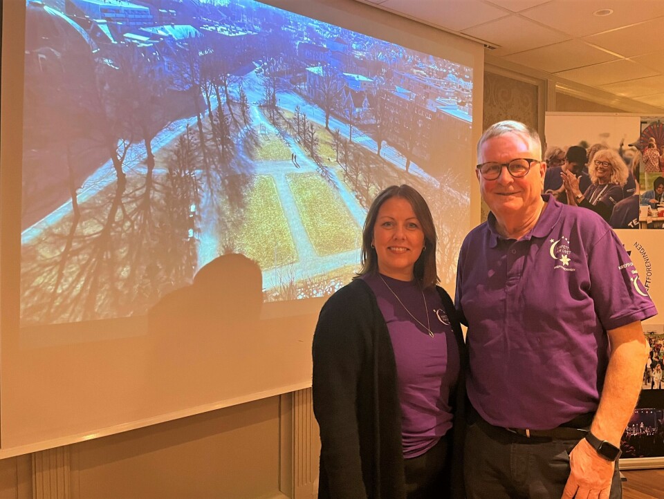 Irene Mellingen Solberg og Steinar Reppesgård fra Sandefjord Kreftforening har stor tro på gjennomføring av arrangementet i Fredrikstad. En kvinne og en eldre man står i lilla t-skjorter foran et bilde av Kirkeparken i Fredrikstad