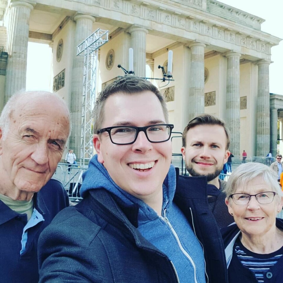 Artikkelforfatteren, Dagsavisens sjefredaktør Eirik Hoff Lysholm (foran), poserer på 18. mars-plassen foran Brandenburger Tor i Berlin i 2017 sammen med sin stefar, mamma og lillebror. Mennesker foran Brandenburger Tor.