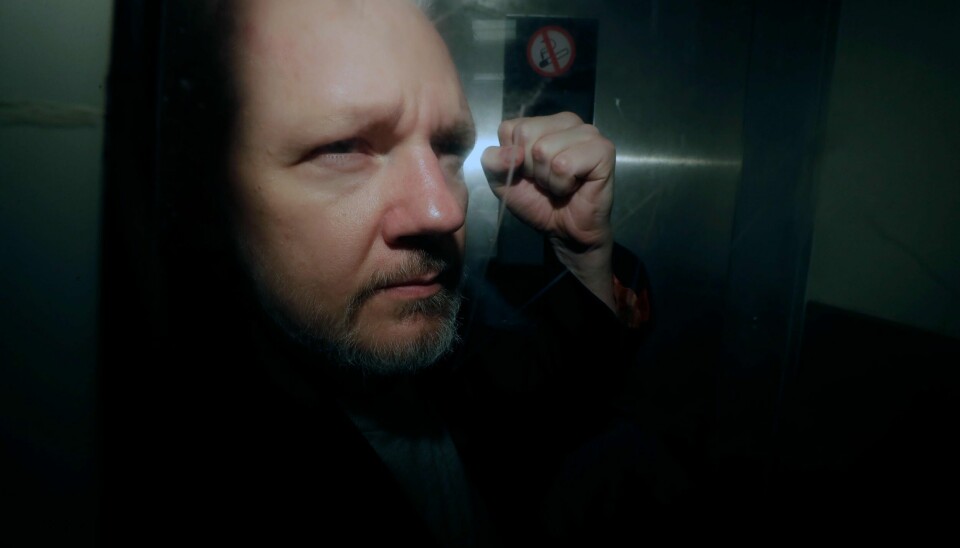 WikiLeaks-grunnleggeren Julian Assange løfter knyttneven idet han blir transportert fra rettssalen i London. Foto: Matt Dunham / AP / NTB scanpix