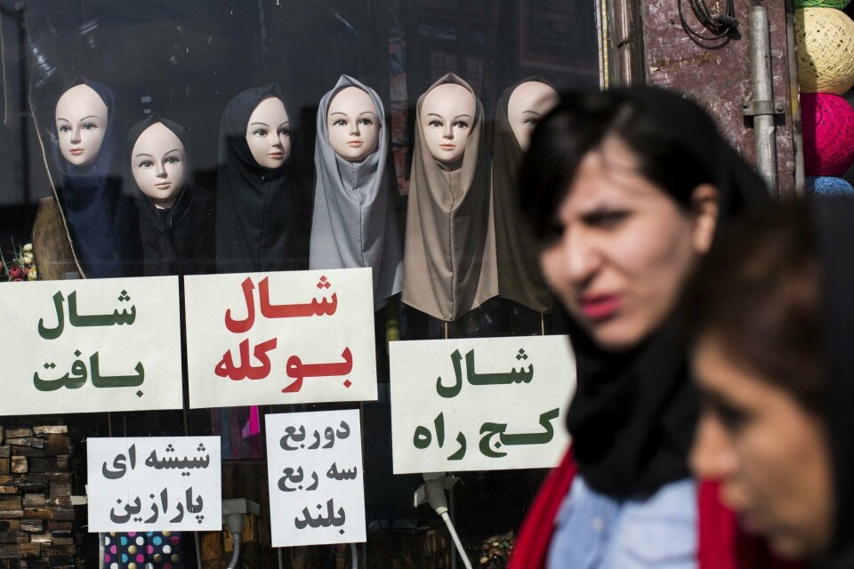 Iranske kvinner går forbi et vindu som selger hijaber. Hodetørkleet er nå i sentrum for protester mot det iranske regimet. Moralpolitiet passer på at iranske kvinner dekker håret, men de har vært mindre aktive etter at president Hassan Rouhani vant makten i 2013. De siste dagene har iranske kvinner tatt det lenger og fjernet hele sløret.