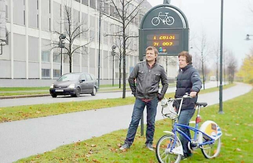 Anders Wengen, førstekandidat på Buskerud Venstres fylkestingsliste, og Lars André Landås i Drammen Venstre, vil gi kommunene drahjelp til å nå målet om å få flere til å sykle. Her ved sykkeltelleren i Elveparken på Bragernes. FOTO: KATRINE STRØM