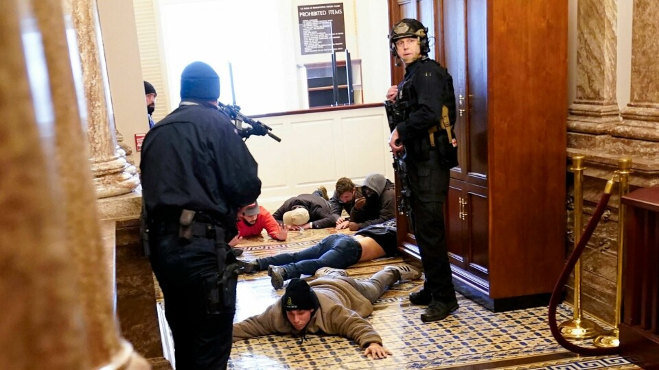 Politiet i kongressbygningen under den voldelige stormingen av nasjonalforsamlingen. U.S. Capitol Police hold protesters at gun-point near the House Chamber inside the U.S. Capitol on Wednesday, Jan. 6, 2021, in Washington. (AP Photo/Andrew Harnik)