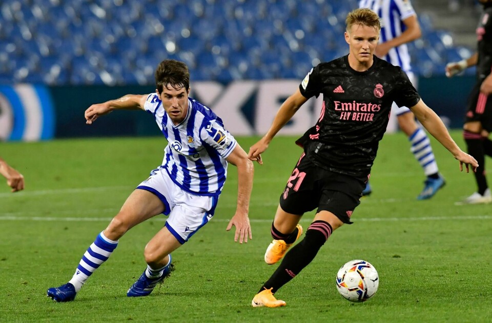 Martin Ødegaard ble raskt en folkehelt i Real Sociedad, og er her i kamp mot sin gamle klubb tidligere i sesongen. Real Madrid's Martin Odegaard fights for the ball against Real Sociedad's Aritz Elustondo during the Spanish La Liga soccer match between Real Sociedad and Real Madrid at the Anoeta stadium in San Sebastián, Spain, Sunday, Sept. 20, 2020. (AP Photo/Alvaro Barrientos)