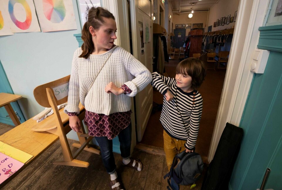 Esteban Solis i 3. klasse på på Nordstrand Steinerskole gjør en albu-korona-hilsen med lærer Maria Gystad før han går inn i klasserommet i mars.Foto: Heiko Junge/NTB