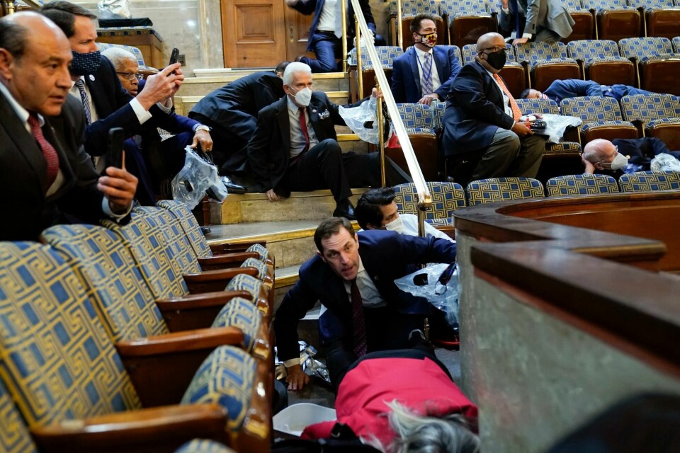 FILE - In this Jan. 6, 2021, file photo people shelter in the House gallery as rioters try to break into the House Chamber at the U.S. Capitol. Arguments begin Tuesday, Feb. 9, in the impeachment trial of Donald Trump on allegations that he incited the violent mob that stormed the U.S. Capitol on Jan. 6. (AP Photo/Andrew Harnik, File) FILE - In this Jan. 6, 2021, file photo people shelter in the House gallery as rioters try to break into the House Chamber at the U.S. Capitol. Arguments begin Tuesday, Feb. 9, in the impeachment trial of Donald Trump on allegations that he incited the violent mob that stormed the U.S. Capitol on Jan. 6. (AP Photo/Andrew Harnik, File)