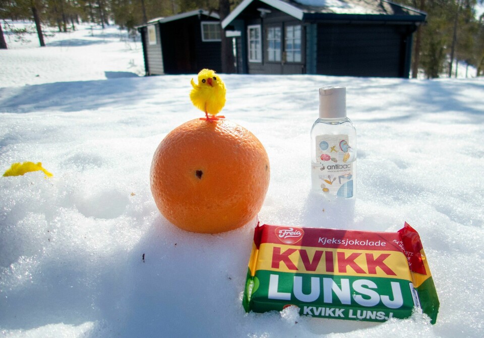 Illustrasjon: Koronapåsken med antibac, kvikk lunsj og appelsin. Påskeferie.