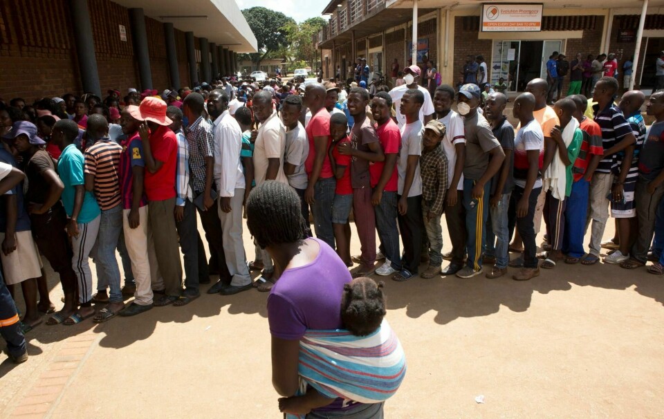 Zimbabwes innbyggere har valget mellom sult eller koronasmitte. Disse står i kø utenfor et supermarked i Harare, i håp om å få kjøpe maismel, som det er mangel på i landet.