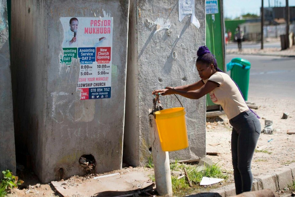 Vask hendene med vann og såpe, sier myndighetene. Det er ikke så lett for dem som ikke har tilgang til vann. Organisasjonen Abahlahli i Sør-Afrika har kjempet for tilgang til vann for slumbeboere. Her samler en kvinne i Khayelitsha utenfor Cape Town vann.