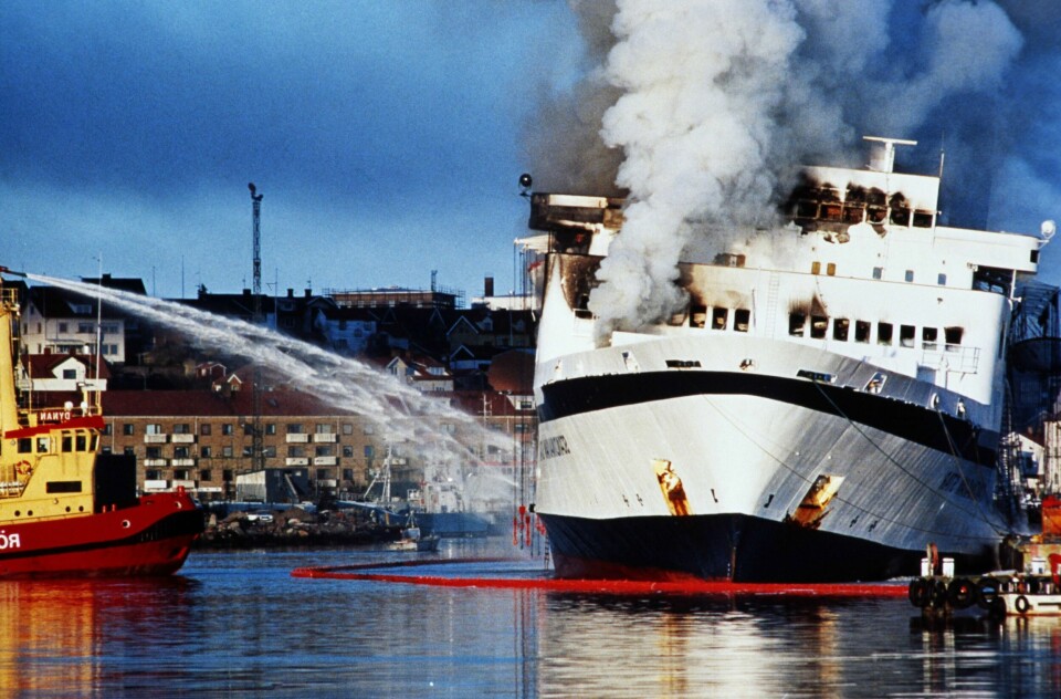 Dette bildet er tatt 8. april 1990, etter at Scandinavian Star er blitt tauet inn til Lysekil i Sverige. Det kommer fortsatt røyk ut av ferja.