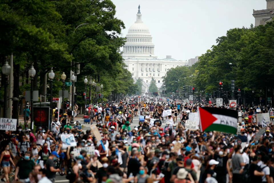 Demonstrasjonene er lørdag i gang på Pennsylvania Avenue i Washington D.C. Demonstrators walk on Pennsylvania Avenue as they protest, Saturday, June 6, 2020, in Washington, over the death of George Floyd, a black man who was in police custody in Minneapolis. Floyd died after being restrained by Minneapolis police officers. (AP Photo/Andrew Harnik)