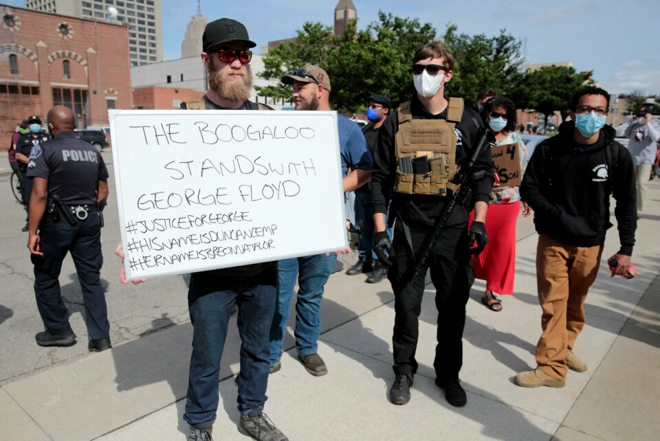 Armed men, one carrying a 'The Boogaloo stands with George Floyd' sign, are seen as protesters rally against the death in Minneapolis police custody of George Floyd, in Detroit, Michigan, U.S. May 30, 2020. Picture taken May 30, 2020. REUTERS/Rebecca Cook Armed men, one carrying a 'The Boogaloo stands with George Floyd' sign, are seen as protesters rally against the death in Minneapolis police custody of George Floyd, in Detroit, Michigan, U.S. May 30, 2020. Picture taken May 30, 2020. REUTERS/Rebecca Cook