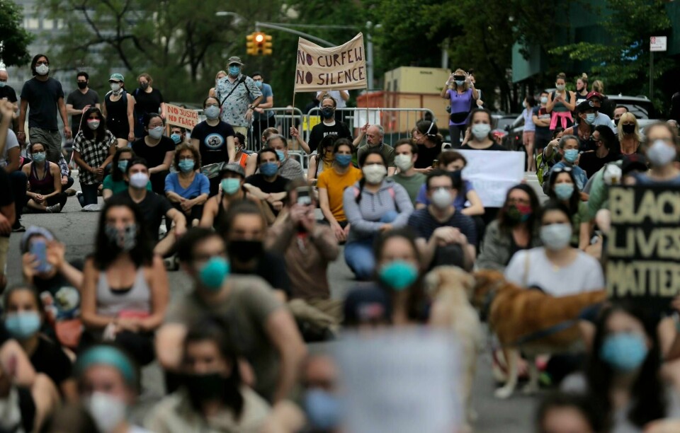 Demonstranter samlet seg nær borgermesterens bolig i New York. Bill de Blasio sier byen har tatt et steg i retning å gjenopprette ro og orden i byen ved hjelp av portforbudet.