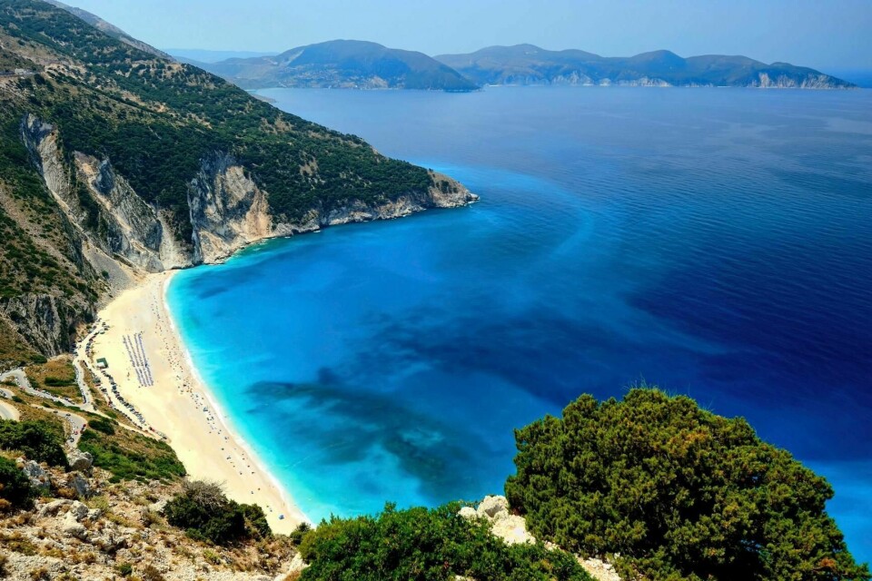 På stranden Myrtos på øya Kefalonia legger du badehåndkleet ditt på lekre, finslipte, hvite steiner.