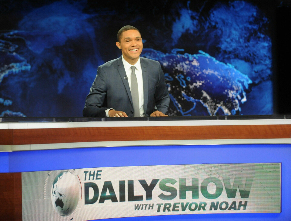 Det er slik vi er vant med å se Trevor Noah, bak skrivebordet i «The Daily Show». FOTO: NTB SCANPIX Det er slik vi er vant med å se Trevor Noah, bak skrivebordet i «The Daily Show». FOTO: NTB SCANPIX