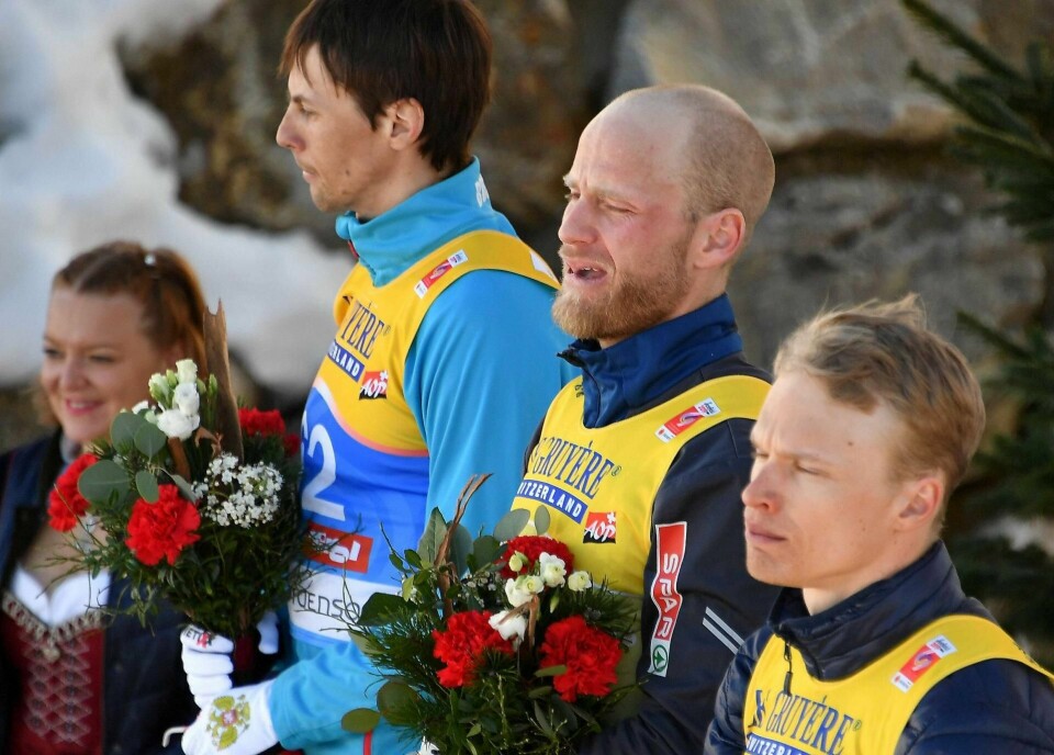 En sterkt beveget Martin Johnsrud Sundby sammen med sølvvinner Alexander Bessmertnykh og bronsevinner Iivo Niskanen (t.h.) på blomsterseremonien.