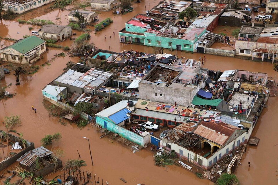 TOPSHOT - Residents stand on rooftops in a flooded area of Buzi, central Mozambique, on March 20, 2019, after the passage of cyclone Idai. - International aid agencies raced on March 20 to rescue survivors and meet spiralling humanitarian needs in three impoverished countries battered by one of the worst storms to hit southern Africa in decades. Five days after tropical cyclone Idai cut a swathe through Mozambique, Zimbabwe and Malawi, the confirmed death toll stood at more than 300 and hundreds of thousands of lives were at risk, officials said. (Photo by ADRIEN BARBIER / AFP) TOPSHOT - Residents stand on rooftops in a flooded area of Buzi, central Mozambique, on March 20, 2019, after the passage of cyclone Idai. - International aid agencies raced on March 20 to rescue survivors and meet spiralling humanitarian needs in three impoverished countries battered by one of the worst storms to hit southern Africa in decades. Five days after tropical cyclone Idai cut a swathe through Mozambique, Zimbabwe and Malawi, the confirmed death toll stood at more than 300 and hundreds of thousands of lives were at risk, officials said. (Photo by ADRIEN BARBIER / AFP)