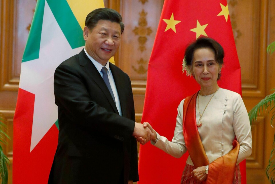 Myanmars sivile leder Aung San Suu Kyi og den kinesiske presidenten Xi Jinping tar hverandre i hånden under toppmøtet.