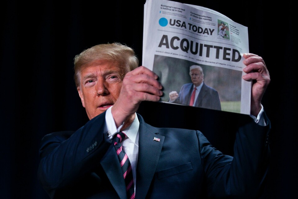 President Donald Trump holder opp dagens utgave av USA Today med overskriften «FRIKJENT» torsdag. Dagen før ble han av sine partifeller funnet ikke skyldig på begge tiltalepunktene i riksrettssaken i Senatet. President Donald Trump holds up a newspaper with the headline that reads 'ACQUITTED' at the 68th annual National Prayer Breakfast, at the Washington Hilton, Thursday, Feb. 6, 2020, in Washington. (AP Photo/ Evan Vucci)