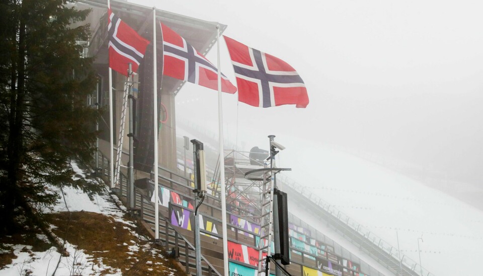 Flaggene viser søndagens vindproblemer i Holmenkollen. Rennet skulle uansett gå for tomme tribuner.