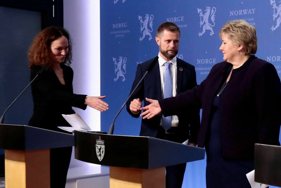 Statsminister Erna Solberg (t.h.) og helseminister Bent Høie (midten) orienterer om nye tiltak for å bekjempe koronaviruset. Høie avverger håndhilsing mellom Solberg og direktør i Folkehelseinstituttet Camilla Stoltenberg. Foto: Lise Åserud/NTB scanpix