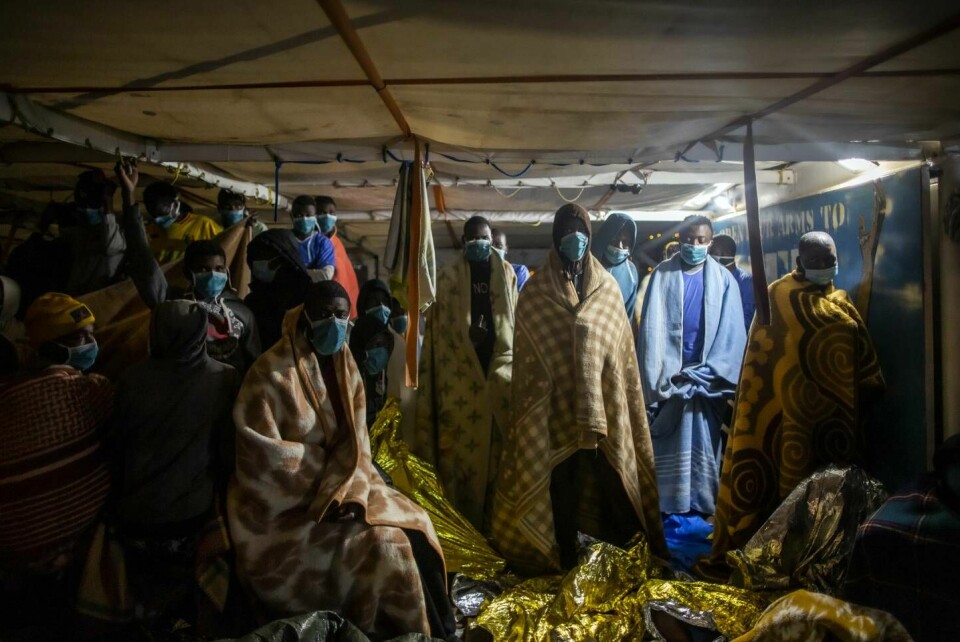 I februar plukket den spanske organisasjonen Open Arms opp flere hundre mennesker i Middelhavet. Organisasjonen hevder at deres redningsoperasjoner er blitt hindret av den libyske kystvakta. Migrants and refugees from from different African nationalities wearing blankets due to the cold, wait on the deck of the Spanish NGO Open Arms boat to disembark after being rescued in the Mediterranean Sea, international waters, Monday, Feb.15, 2021. Various African migrants drifting in the Mediterranean Sea after fleeing Libya on unseaworthy boats have been rescued. In recent days, the Libyans had already thwarted eight rescue attempts by the Open Arms, a Spanish NGO vessel, harassing and threatening its crew in international waters. (AP Photo/Bruno Thevenin)