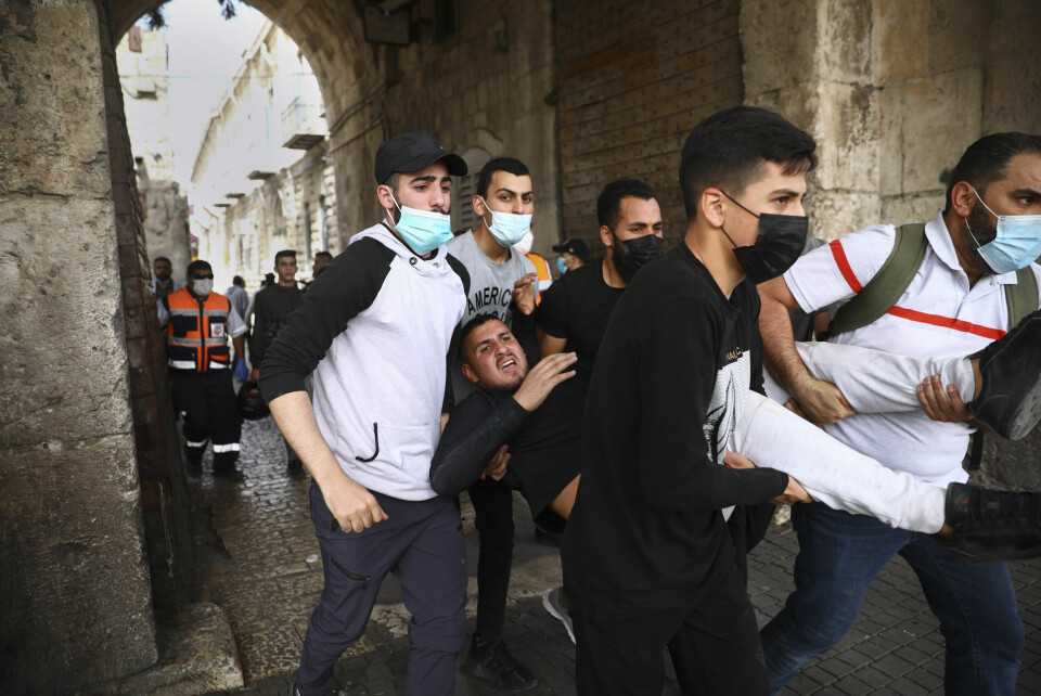En skadd demonstrant evakueres etter sammenstøt mellom israelske sikkerhetsstyrker i Jerusalems gamleby mandag. Palestinere bærer vekk en skadd demonstrant gjennom i gamlebyen i Jerusalem. Foto: Oded Balilty / AP / NTB