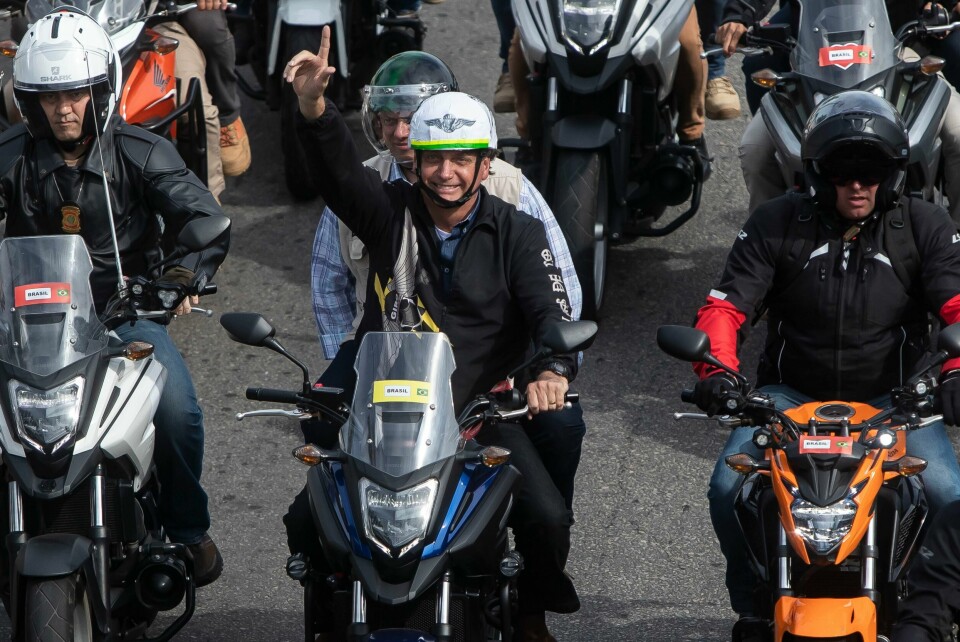 Jair Bolsonaro. -med hjelm, men uten munnbind – ledet an i en MC-parade gjennom Rios gater søndag. Jair Bolsonaro. -med hjelm, men uten munnbind – ledet an i en MC-parade gjennom Rios gater søndag. Foto: Bruna Prado / AP / NTB