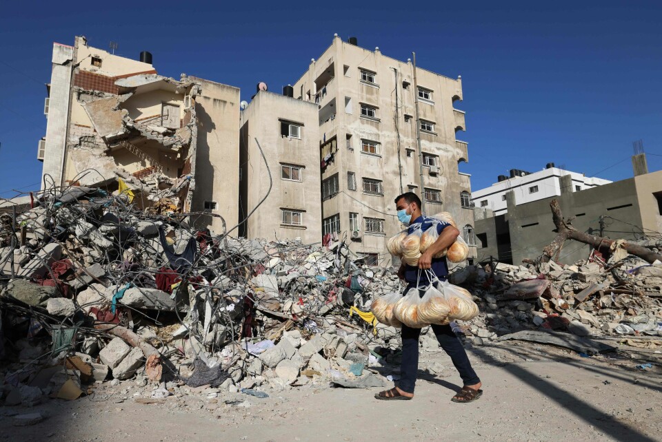 En palestinsk mann går foran ruinene av et ødelagt bygg i Gaza by. En palestinsk mann går foran ruinene av et ødelagt bygg i Gaza by.