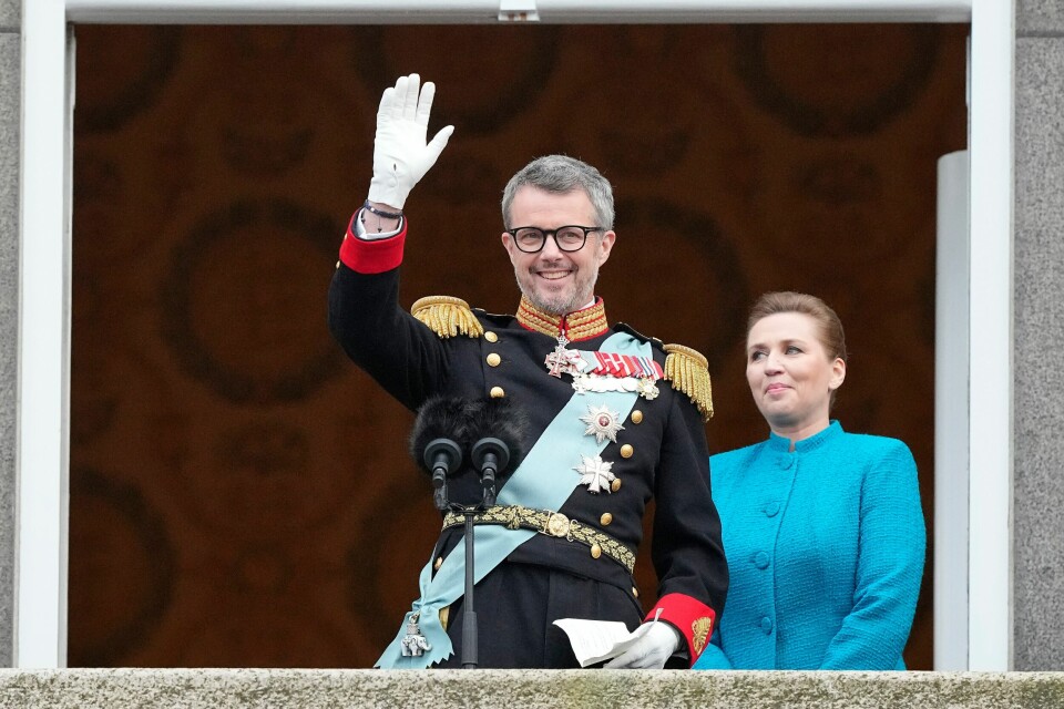 Kong Frederik 10. vinket til folket, med dansk statsminister Mette Fredriksen i bakgrunnen. Kong Frederik 10. tok søndag over rollen som Danmarks monark etter sin mor dronning Margrethe II. Statsminister Mette Frederiksen presenterte den nye kongen fra balkongen på Christiansborg slott. Foto: Martin Meissner / AP Photo
