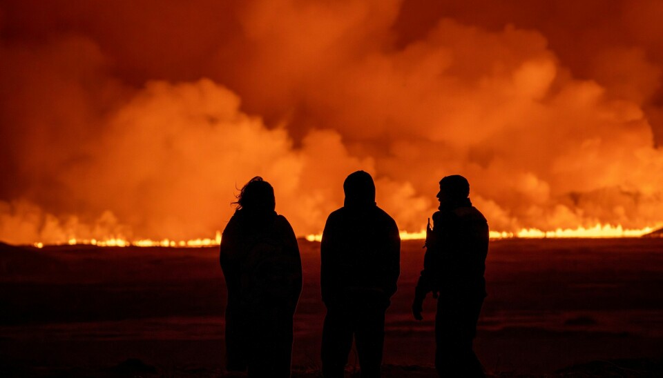 Bildet er fra vulkanutbruddet 18. desember 2023. Nysgjerrige betrakter vulkanutbruddet som lyste opp himmelen med en oransje glød sørvest for Reykjavik 18. desember. Foto: Marco Di Marco / AP / NTB