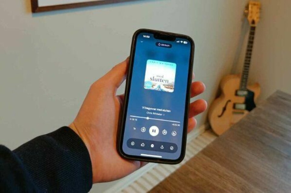 Vi har testet ut 6 populære lydbok-apper. Hånd holder mobiltelefon.