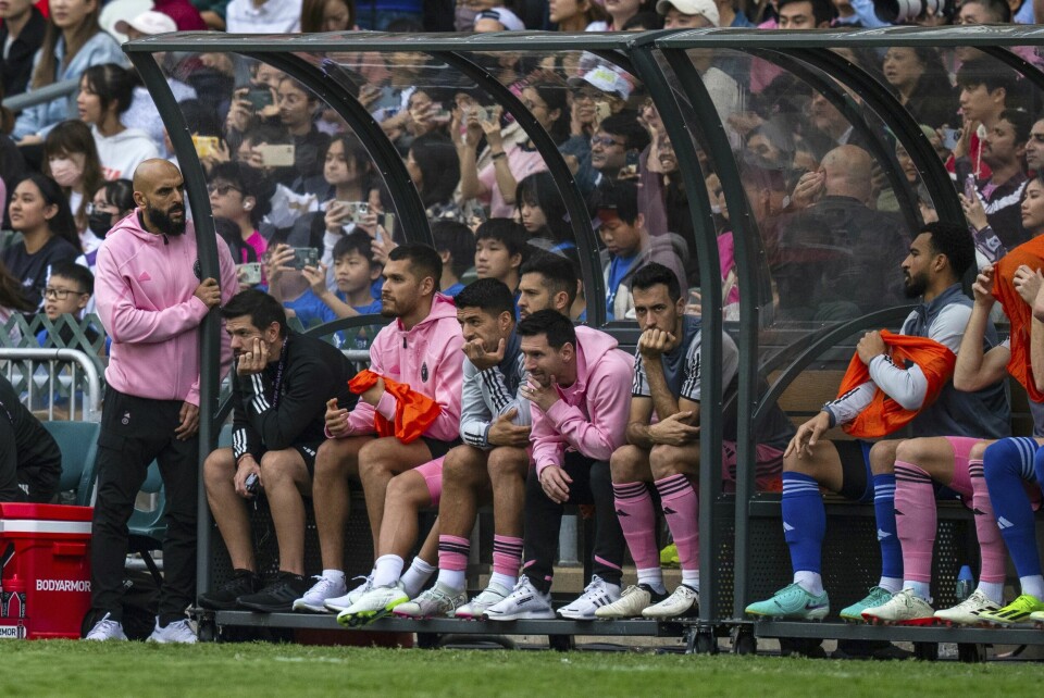 Lionel Messi (i rosa i midten) ble sittende på benken under hele kampen i Hong Kong. Lionel Messi ble sittende hele kampen på benken mot Hongkong All Stars. Foto: Louise Delmotte / AP / NTB
