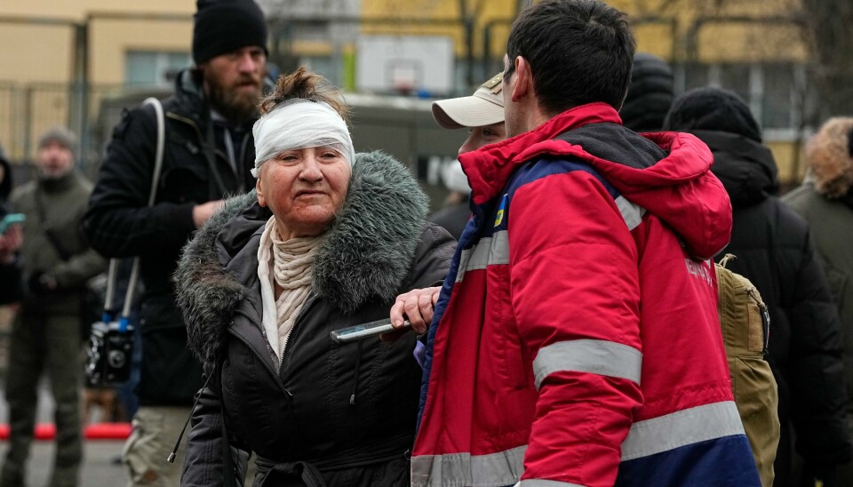 En redningsarbeider hjelper en kvinne utenfor en boligblokk som ble ødelagt i et russisk angrep mot Kyiv onsdag. En redningsarbeider hjelper en kvinne utenfor en boligblokk som ble ødelagt i et russisk angrep mot Kyiv onsdag. Foto: Efrem Lukatsky / AP / NTB