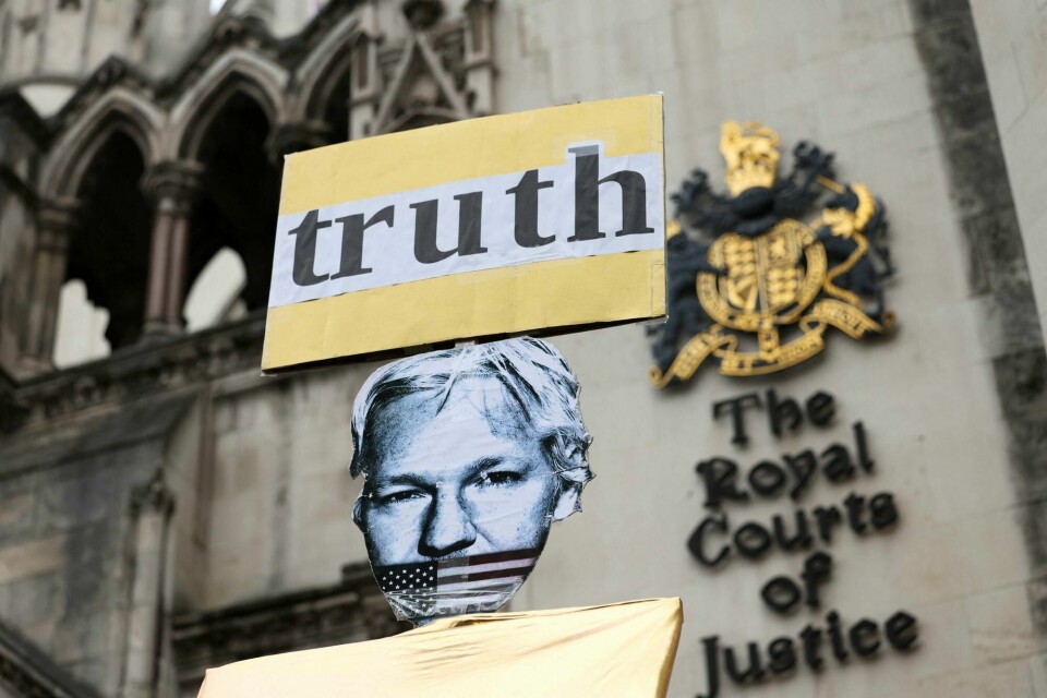 En plakat av Julian Assange utenfor rettslokalet tirsdag. A view of a placard depicting WikiLeaks founder Julian Assange outside the high court on the day Assange appeals against his extradition to the United States, in London, Britain, February 20, 2024. REUTERS/Isabel Infantes