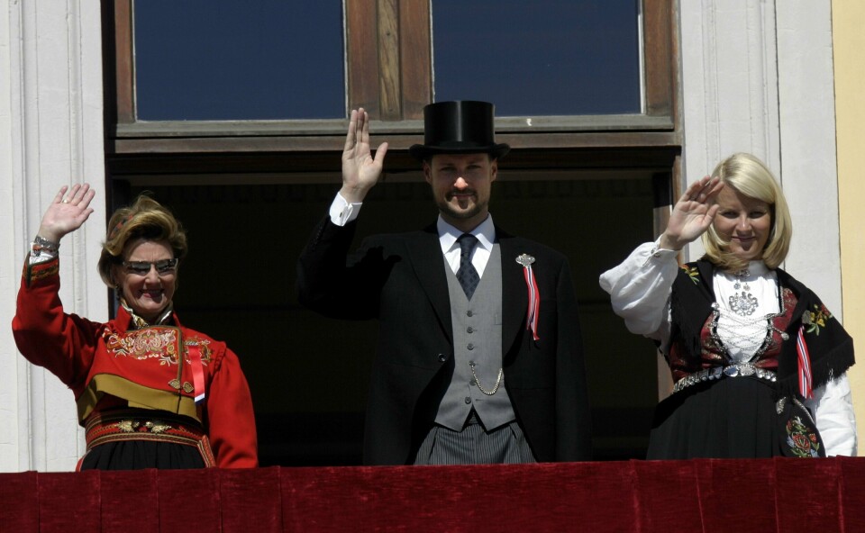 Dronning Sonja, kronprins Haakon Magnus og kronprinsesse Mette-Marit hilste barnetoget fra slottsbalkongen på 17. mai i 2005. Kong Harald var fraværende etter å ha gjennomført hjerteoperasjoner kort tid i forkant. Dronning Sonja, kronprins Haakon Magnus og kronprinsesse Mette-Marit hilste barnetoget fra slottsbalkongen på 17. mai i 2005. Kong Harald var fraværende etter å ha gjennomført hjerteoperasjoner kort tid i forkant. Foto: Jarl Fr. Erichsen / NTB