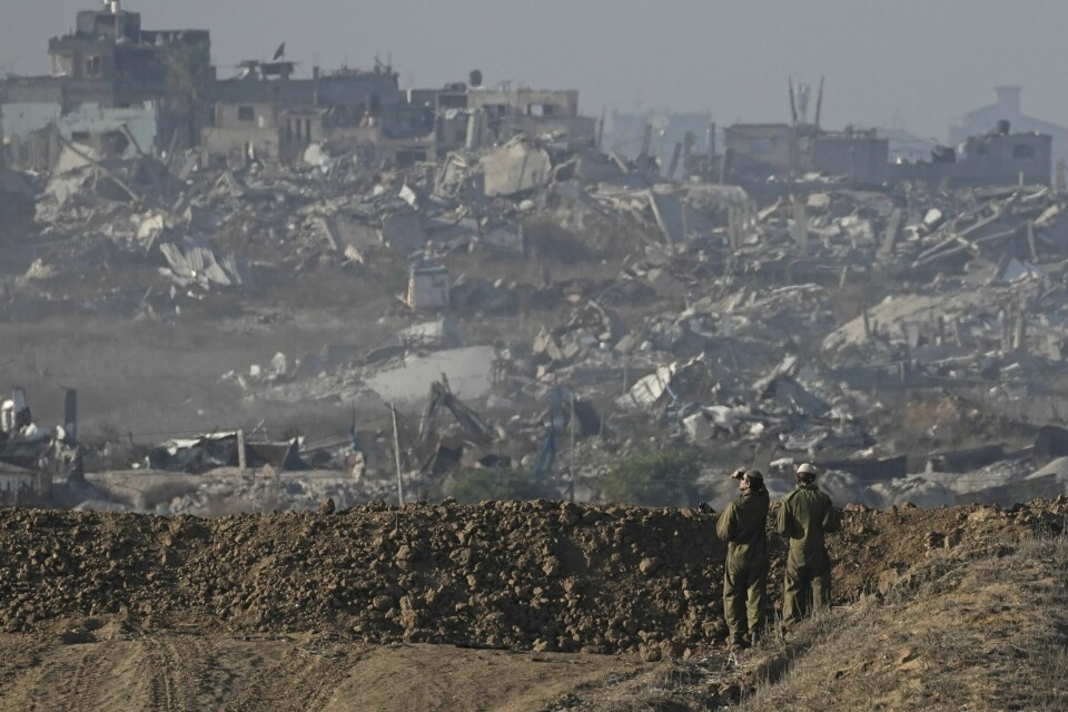 Israelske soldater står ved grensen mellom Israel og Gaza og ser på et område i Gaza by som er rasert av israelske styrker. Israelske soldater står ved grensen mellom Israel og Gaza og ser på et område i Gaza by som er rasert av israelske styrker. Foto: Tsafrir Abayov / AP / NTB