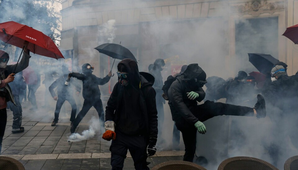 Demonstranter i en sky av tåregass i sammenstøt med politiet i Nantes vest i Frankrike lørdag. Demonstranter i en sky av tåregass i sammenstøt med politiet i Nantes vest i Frankrike lørdag. Foto: Jeremias Gonzalez / AP / NTB