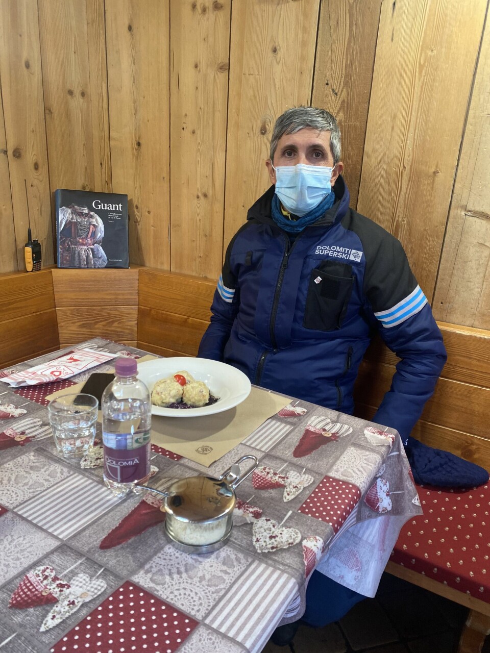 Denis Rocchi gjør seg klar til lunsj – den lokale spesialiteten canderli, en rett ikke ulik våre komler. Denis Rocchi sitter ved et bord med tallerken og mat foran seg. Han har på seg munnbind.