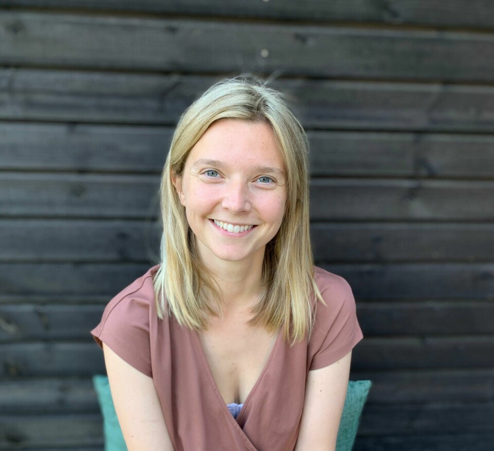 Det beste med jobben er å møte nye mennesker, synes Emilie Berg Slangsvold. Hun tok over jobben som sjef for Kulturhuset i Gamlebyen tidligere i år. En smilende Emilie Berg Slangsvold, foran mørk vegg