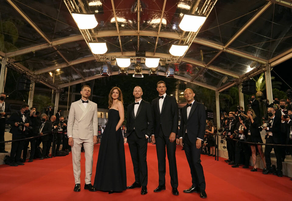 Eskil Vogt (ytterst til høyre) på den røde løperen i Cannes før premieren på «Verdens verste menneske», sammen med Anders Danielsen Lie (fra venstre), Renate Reinsve, regissør Joachim Trier og Herbert Nordrum. Teamet bak den norske filmen omkranset av fotografer i Cannes torsdag. Fra venstre: Anders Danielsen Lie, Renate Reinsve, Joachim Trier, Herbert Nordrum og Eskil Vogt. Foto: Brynn Anderson / AP / NTB